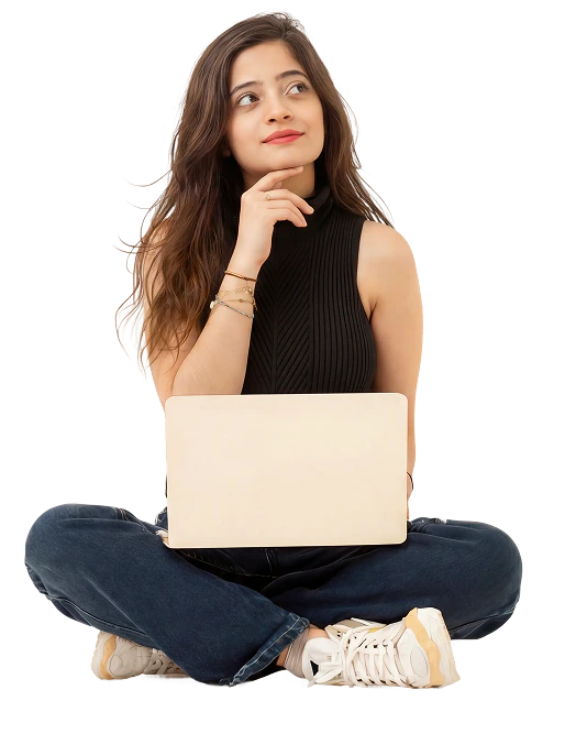 Fatima sitting cross-legged with a laptop, looking up and thinking